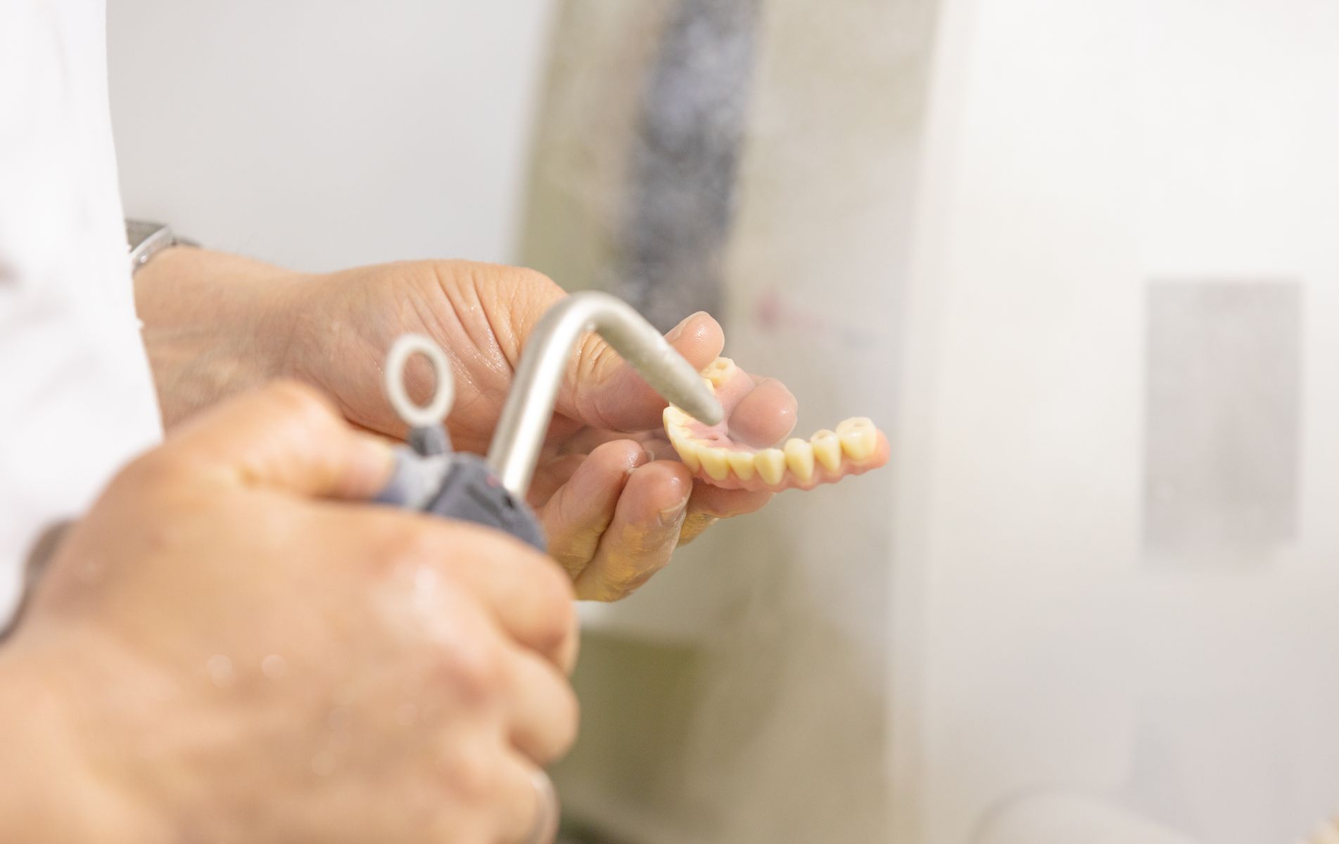 Limpieza diaria de prótesis dental bajo el grifo para eliminar restos de placa